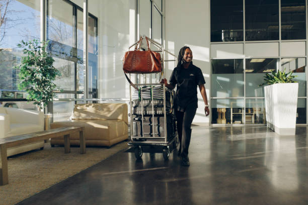 hotellobby mit mitarbeitern und gästen - luggage cart stock-fotos und bilder