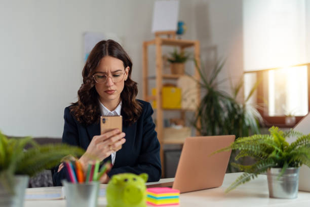 Business woman working from home. Business woman using phone at home for work stock photo