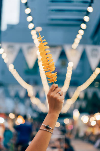 Close up shot of an anonymous woman holding chips on a stick.