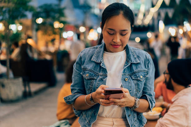 istock Asian Woman Texting On Her Mobile Phone 1400301598