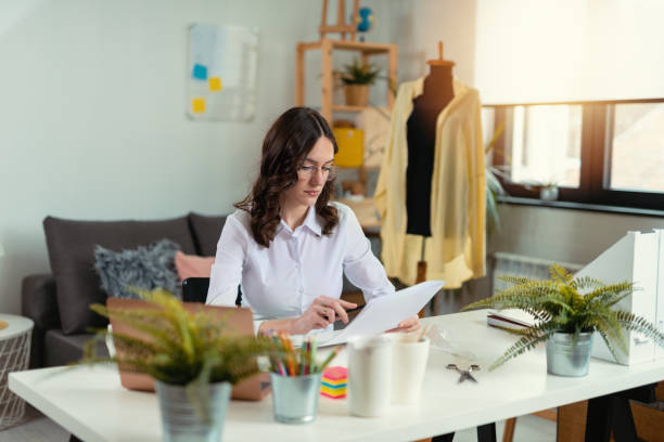 Fashion designer woman working on her designs in the studio stock photo