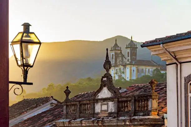 Facade of historic colonial style houses with their lanterns and church in the background in the city of Ouro Preto state of Minas Gerais, Brazil