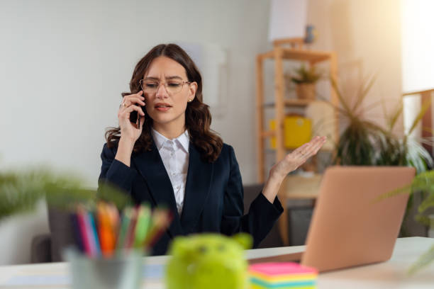 Angry businesswoman talking on phone from office stock photo