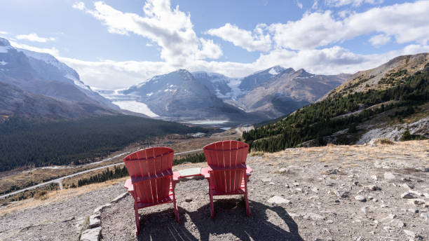 istock Two red chairs overlooking beautiful view on alpine valley with mountains and glaciers,Jasper,Canada 1400302762