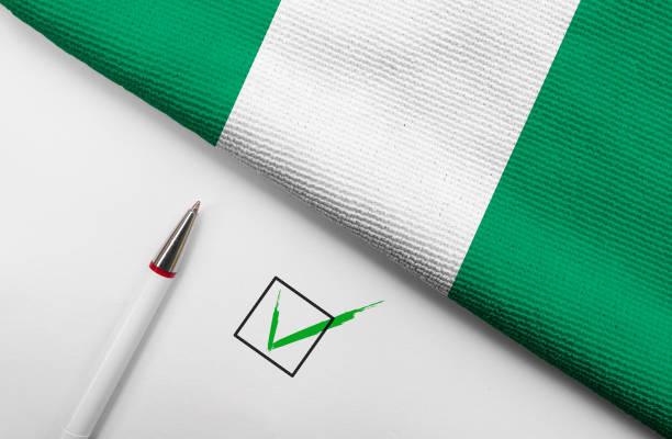 Pencil, Flag of Nigeria and check mark on paper sheet stock photo