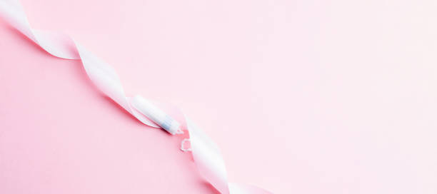 menstrual tampon feminine hygiene. pink ribbon with menstrual tampon on pink background. menstruation feminine period. sanitary hygiene concept. medical healthcare gynecological banner. - menstruation tampon gynecological examination sex imagens e fotografias de stock