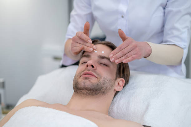 istock Young man having face massage in a spa salon 1400307868