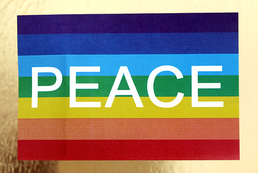 Rainbow flag with text PEACE and golden background