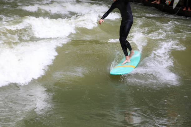 istock athletic man balancing on the surfboard while riding the wave 1400311278