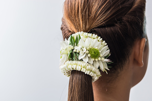 The back of a young woman with flower hair nets.