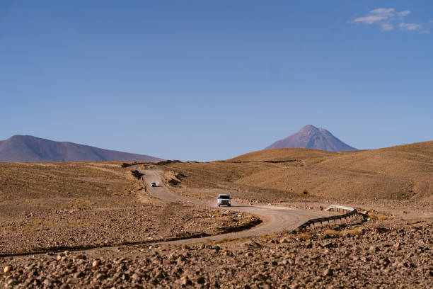 Scenic volcano landscape in Chile. Volcano Parinacota in Arica y Parinacota region. Volcanic cone snow mountain summit above the lake at the sunset on altiplano in South America Andes