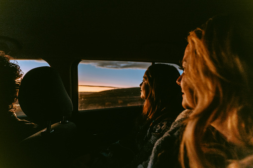 Women watching sunset from car window