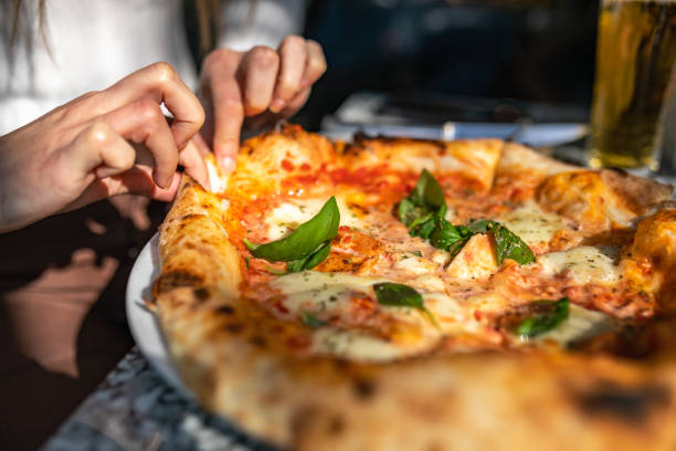 피자 한 조각을 가져 오는 인식 할 수없는 여성 - pizzeria 뉴스 사진 이미지