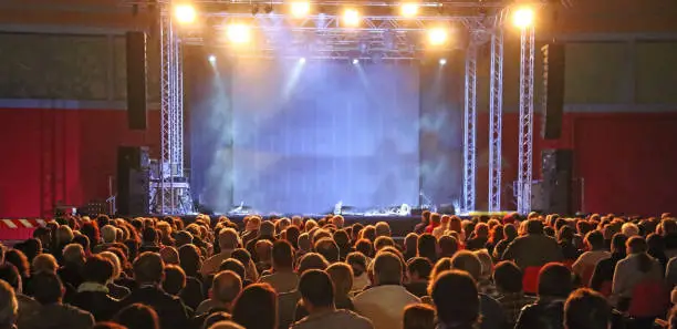 people spectators waiting for the start of the concert in the theater with the stage without any and customizable at will