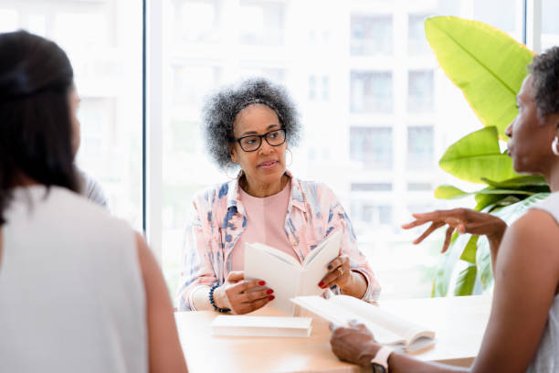 istock Female friends meet to discuss book 1400319232