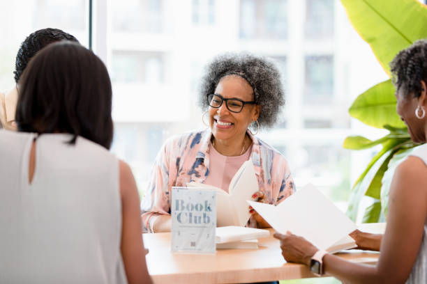 istock Senior woman smiles as group enjoys discussing book 1400319341