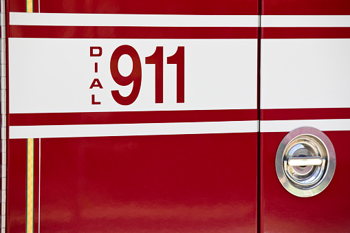 Red and yellow fire engine in garage bay in New England fire station.