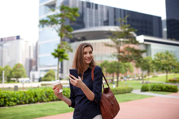istock Young woman using phone and going up on stairs Hong Kong 1400337449