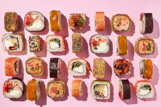 istock Various sushi rolls on pink background, top view. 1400339141