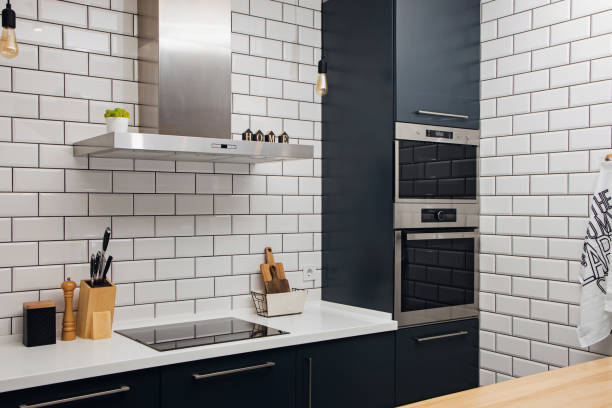 istock Stylish trendy kitchen with white tile and dark facades 1400339416