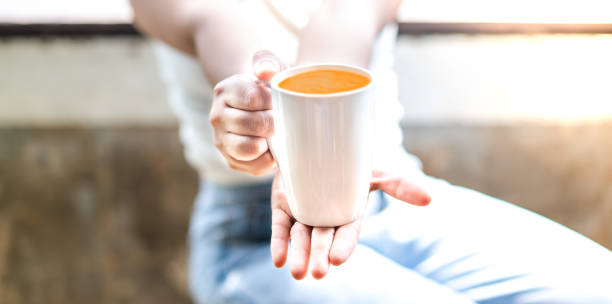 Woman hand holding cup with tea while sitting and relaxing in the living room. And copy space.