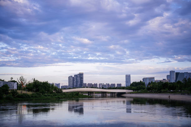 Modern buildings and bridges along the river at dusk