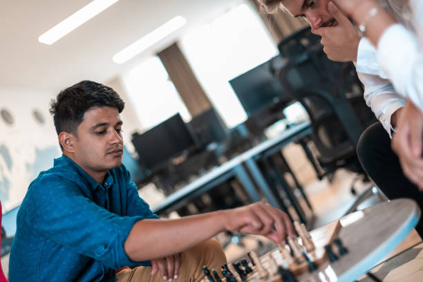 istock Multiethnic group of business people playing chess while having a break in relaxation area at modern startup office 1400345194
