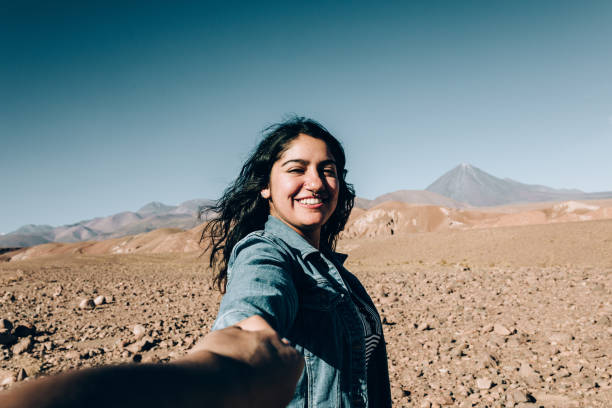 Young Chilean woman holding viewer´s hand at Atacama desert Young Chilean woman holding viewer´s hand at Atacama desert chile tourist stock pictures, royalty-free photos & images