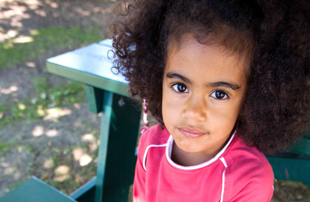 Portrait of a cute young African American girl seated on the floor