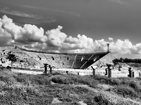 Stark and stunning original architecture shown in black and white to produce the feeling of drama, age, and poignant scene.  The theater is still used today in Caesarea, Israel.  The first two rows of seats are from the original architecture, the remainder have been reconstructed.