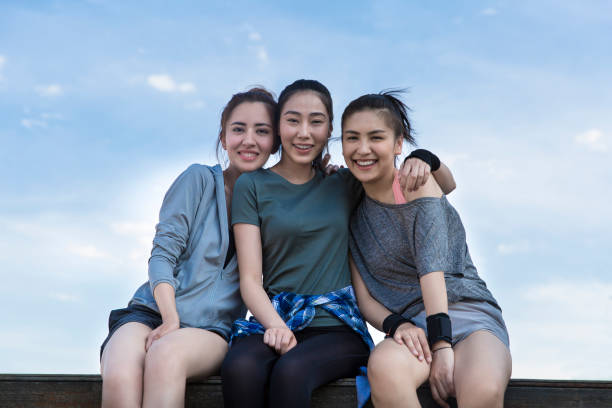 trois jeunes femmes au sommet d’un bâtiment moderne de la ville par une journée d’été ensoleillée - stock photo - short phrase photos et images de collection