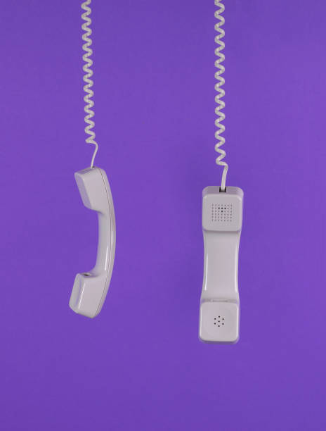 istock Two light retro handsets on a purple background. Minimal concept. 1400350594