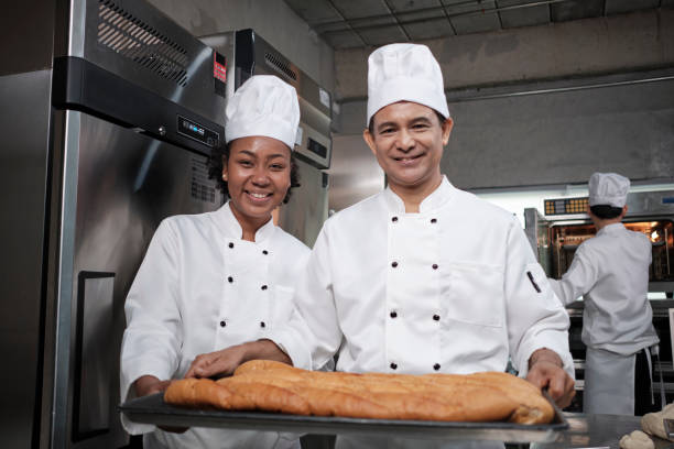 istock Two professional chefs with baking bread, smile and are cheerful in the kitchen. 1400351353