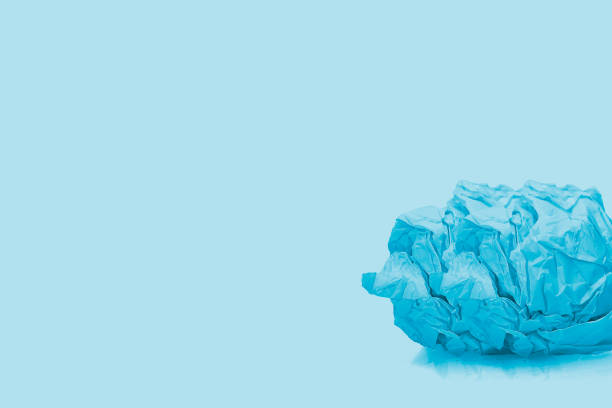 Crumpled blue paper balls isolated on blue background.