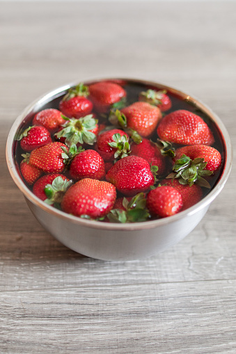 Vibrant Red Strawberries Washing in a Stainless Steel Bowl With Water and White Vinegar.