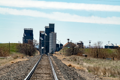 Railroad tracks leading into small community in central Montana on farm and ranch prairie land. This is in northwest USA.