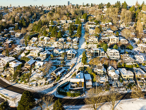 Winter snow covers streets and houses on a hill.  A winter day in the Pacific Northwest.