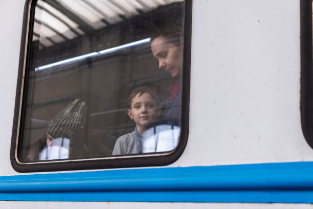 Young boy departing Ukraine looking out window at Lviv train station stock photo