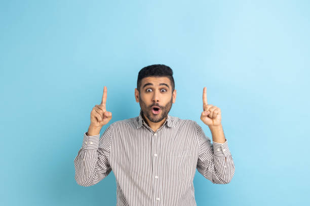 istock Bearded businessman pointing up at empty place for ad content and expressing astonishment. 1400354556