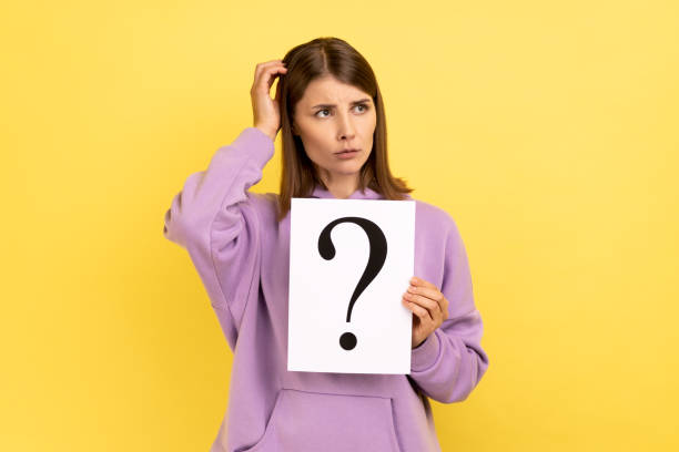 istock Woman looking away, holding paper with question mark, thinks about tasks. 1400354813