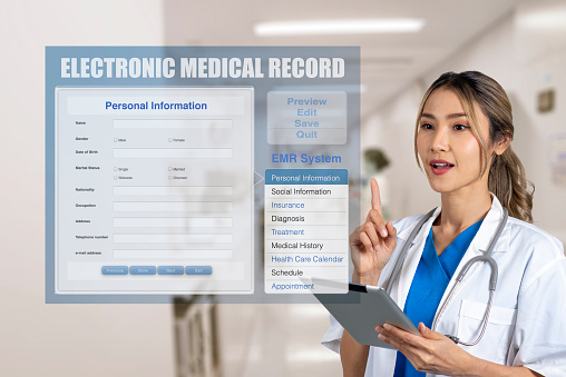 Female doctor holding digital tablet while another hand point to display screen that showing electronic medical record on hospital background.