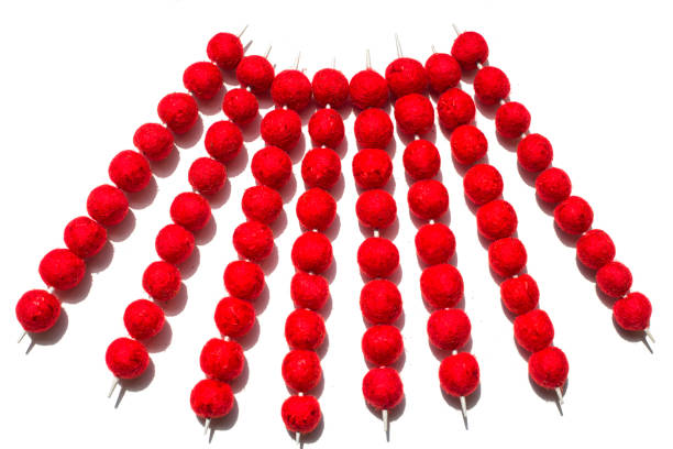 bolas de lã de feltro vermelho usadas em agulhas de tricô em um fundo branco - felt wool sphere textile - fotografias e filmes do acervo