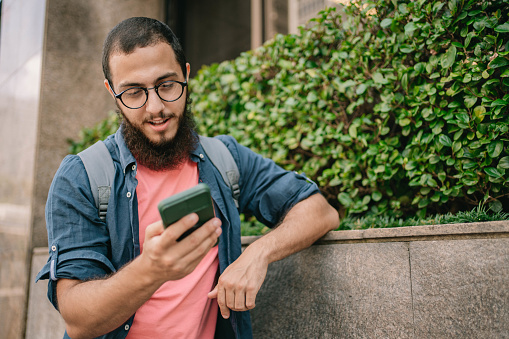 University student using smart phone at Paulista Avenue in Sao Paulo , Brazil