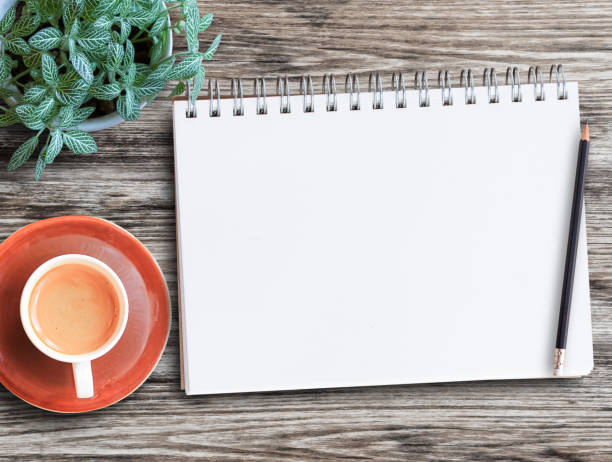 istock Top view notebook with blank pages, coffee mugs and small plant pots on a wooden table 1400362462