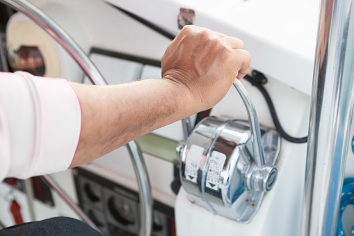 Man driving a boat. Man's hand controlling the accelerator of a boat.