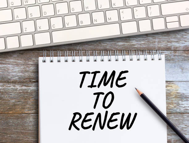 istock Top view with time to renew text in notebook,pencil,keyboard and coffee on wood table 1400363360