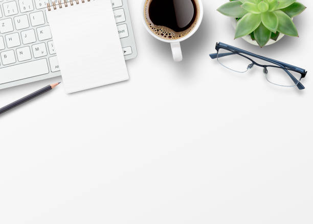 istock Blank notebook, computer keyboard,coffee,glasses and other office equipment on white office desk. 1400363435