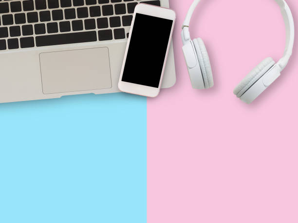 istock White headphone, smartphone,laptop computer on blue and pink background. 1400363483