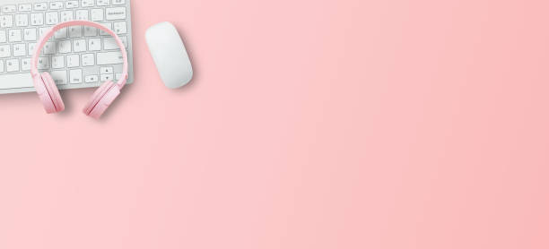 istock Top view with call center desktop, headset and accessories on pink table background. 1400364244