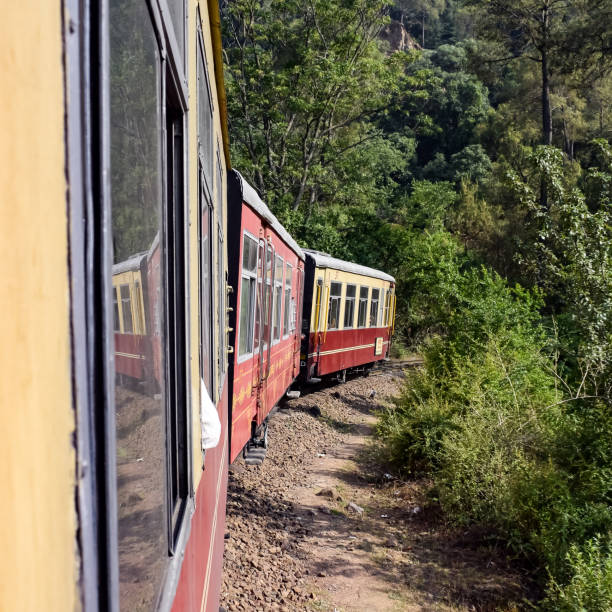 istock Toy Train moving on mountain slopes, beautiful view, one side mountain, one side valley moving on railway to the hill, among green natural forest. Toy train from Kalka to Shimla in India 1400366548